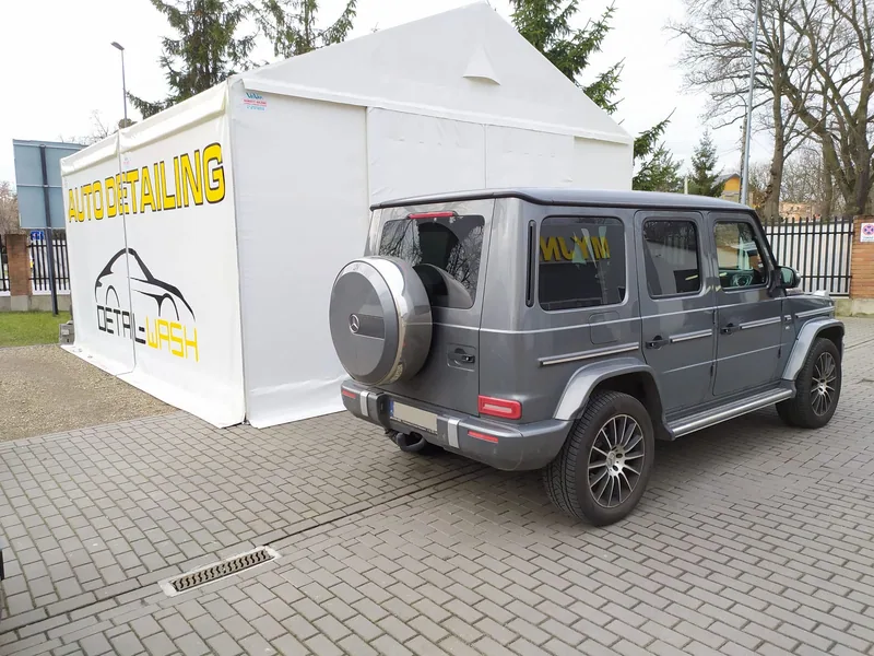 Mercedes klasy G obok namiotu autodetailingu
