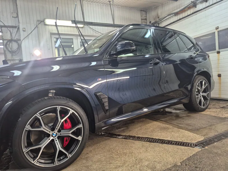 Ciemne BMW w hali Detail-Wash, widok z boku