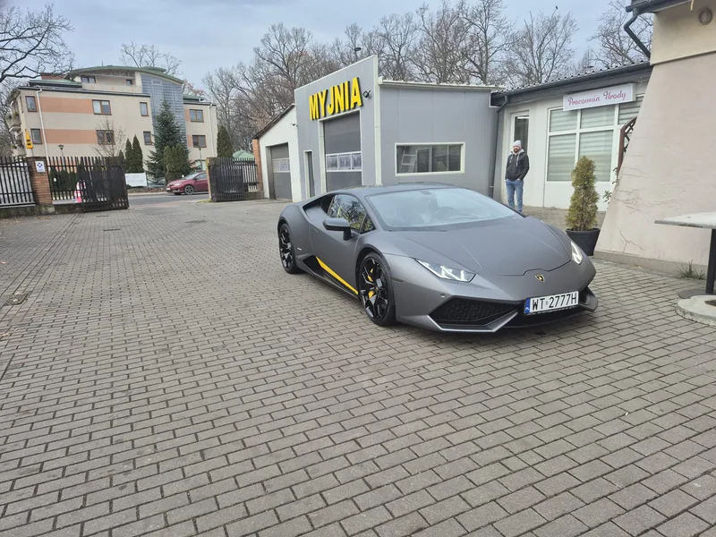 Szare Lamborghini przed punktem Detail-Wash, ujęcie z przodu