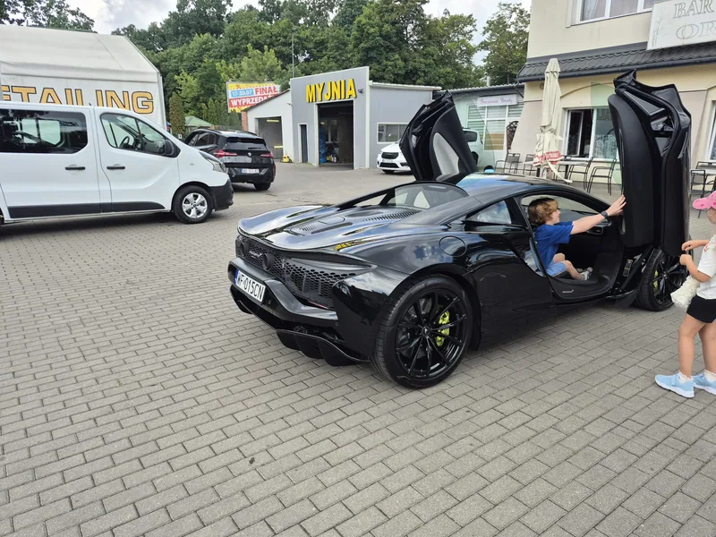 Czarny McLaren z otwartymi drzwiami na placu Detail-Wash