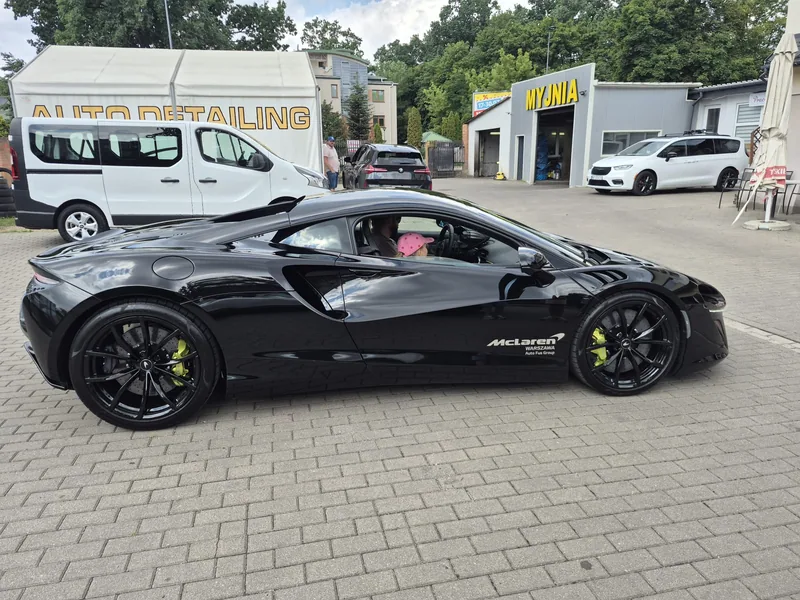 Czarny McLaren na placu myjni, widok z boku